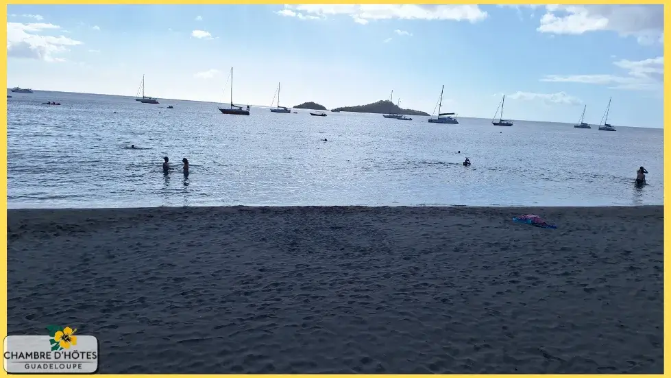 La célèbre plage de Malendure à Bouillante avec vue sur les Îlets Pigeon, illustrant les plages de sable noir volcanique caractéristiques de la côte sous le vent à Basse-Terre en Guadeloupe