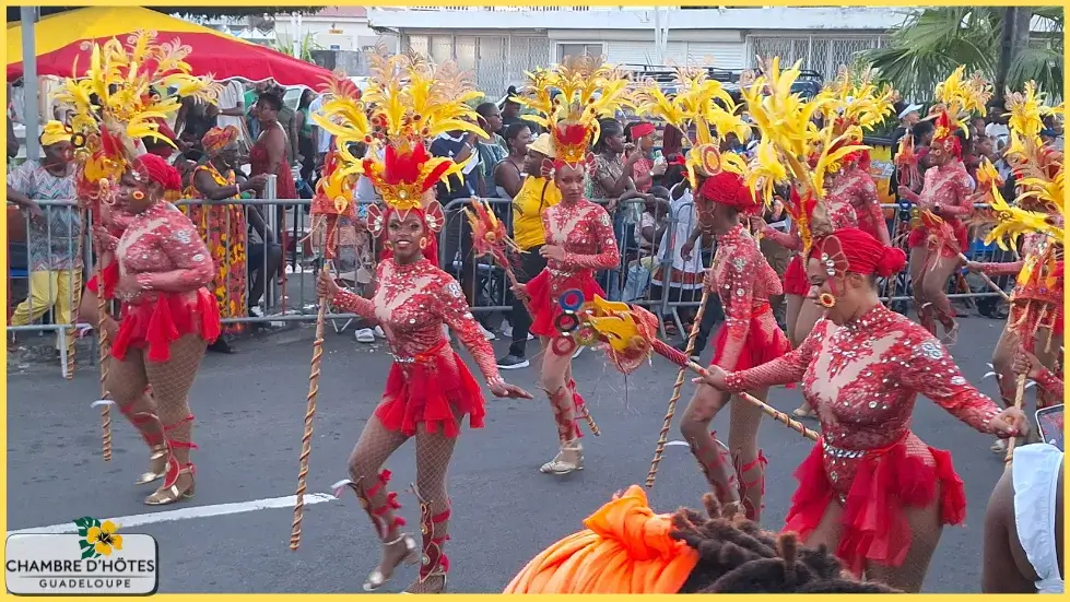 Danseuse arborant un magnifique costume à plumes rouges lors du défilé du Carnaval 2024 aux Abymes, une activité culturelle majeure à ne pas manquer en Guadeloupe