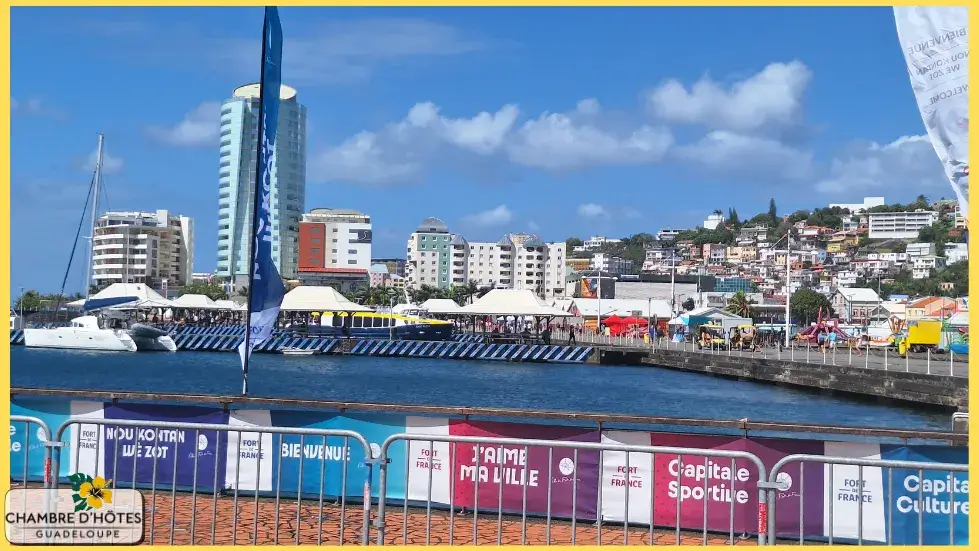 Vue panoramique dégagée sur la ville de Fort-de-France en Martinique, avec la silhouette moderne de la Tour Lumina se détachant sur l'horizon