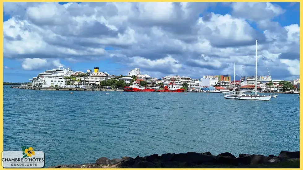 Vue spectaculaire depuis le MACTE sur le front de mer de Pointe-à-Pitre, englobant le marché de la Darse, la Place de la Victoire et les bateaux de croisière à quai