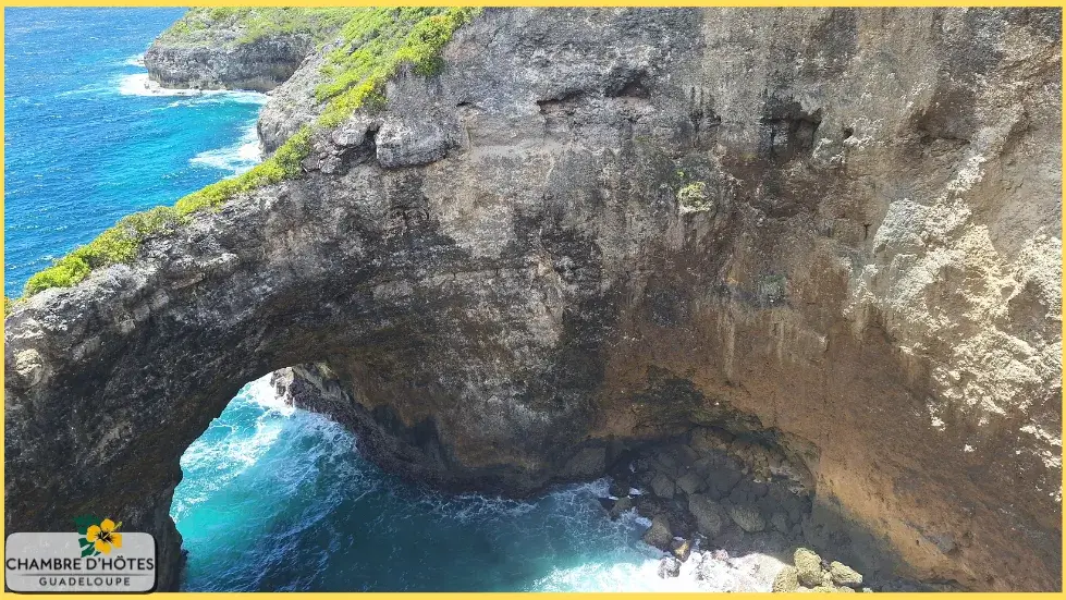 Vue vertigineuse sur le gouffre naturel à ciel ouvert de Gueule Grand Gouffre, creusé par l'océan dans la falaise à Marie-Galante