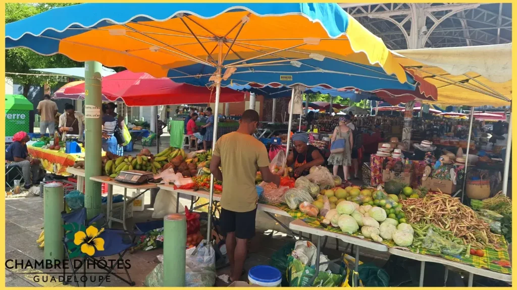 Étalages colorés de fruits et légumes frais avec des marchands au marché central de Pointe-à-Pitre en Guadeloupe